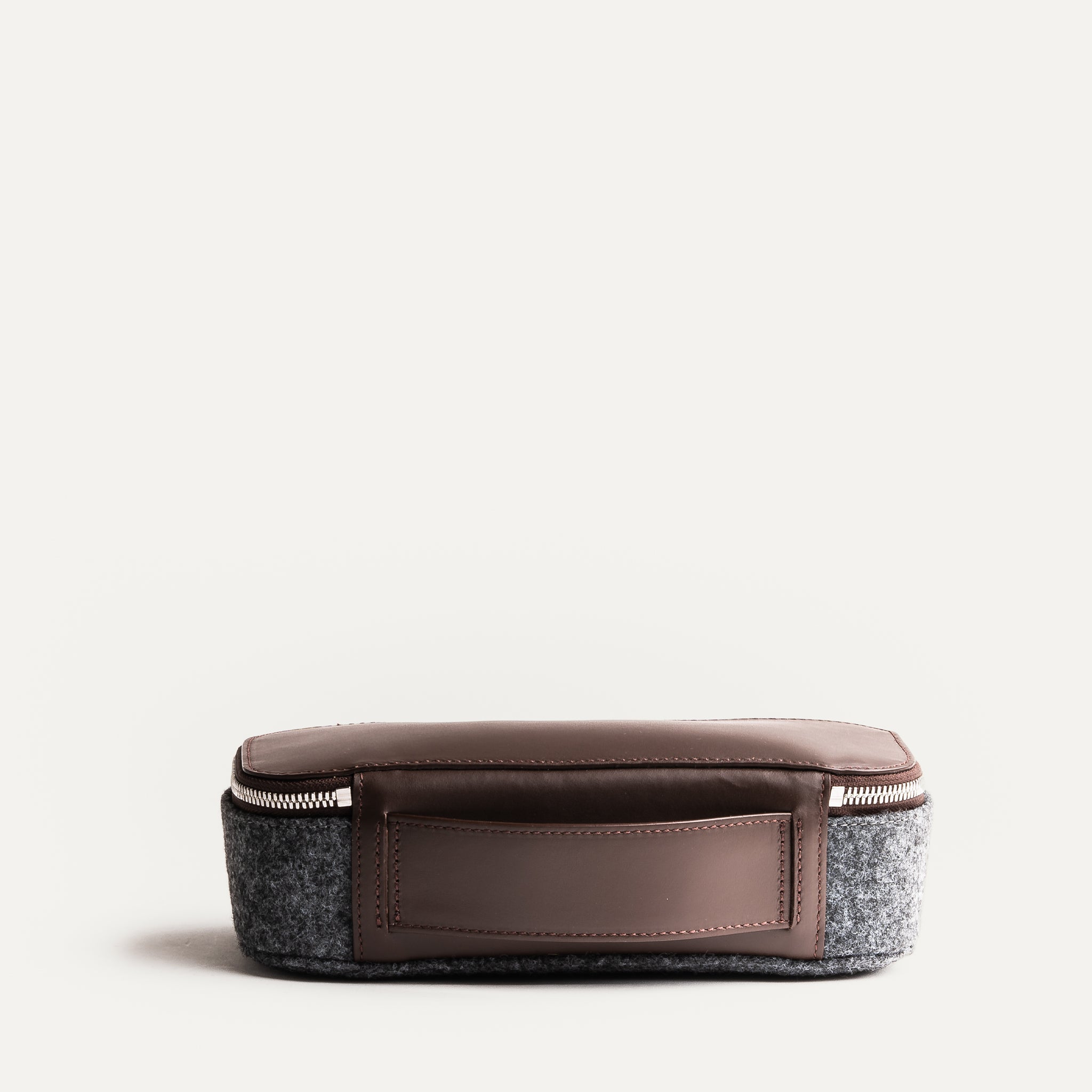 Trousse de toilette homme fermée en cuir marron et feutre gris, parfaite pour voyager.