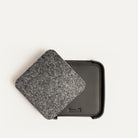 Dessous de verre personnalisé en cuir noir et feutre gris, superposés en présentation produit.