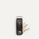 Porte clé luxe en cuir noir avec trois clés partiellement sorties, vu de face sur fond neutre.