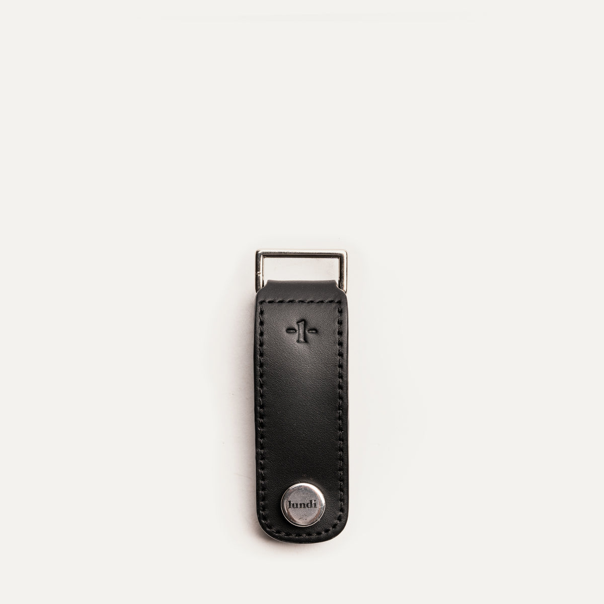 Porte clé personnalisé en cuir noir avec finition métal, posé à plat sur fond clair, vu de face.