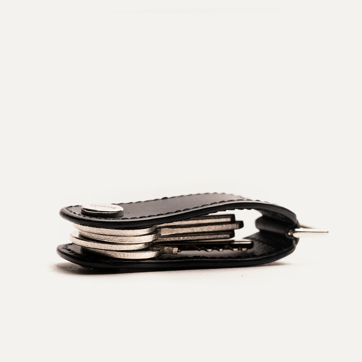 Porte clé homme en cuir noir, vu de profil, montrant les clés rangées à l'intérieur de l'étui.