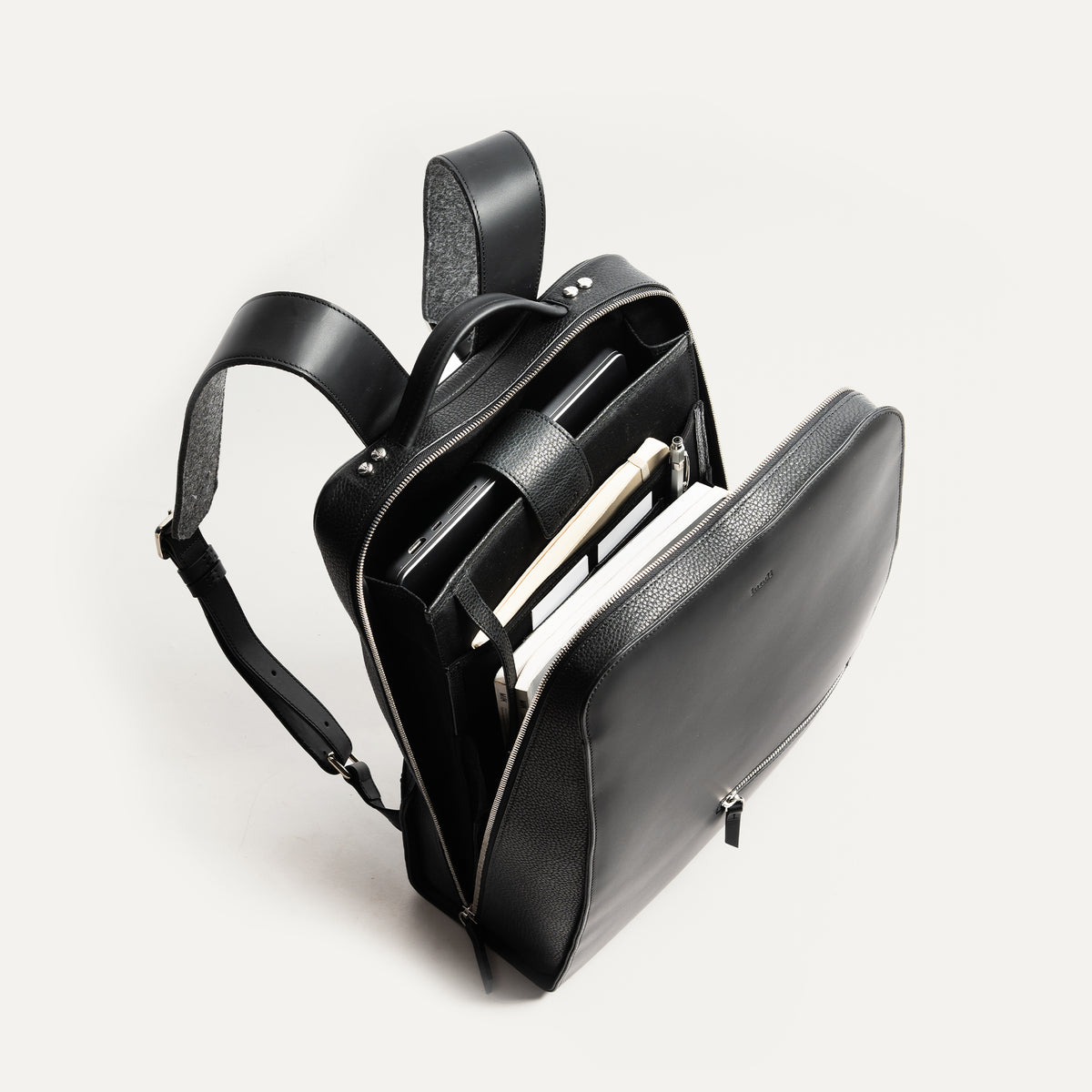 sac à dos urbain homme en cuir noir, silhouette structurée et élégante.