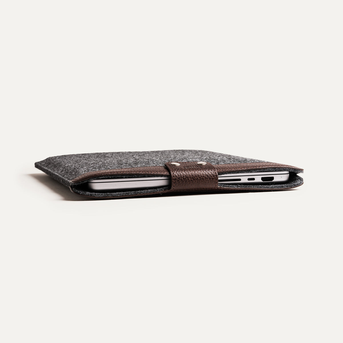 Pochette Mac en cuir marron, profil fin et protection ajustée.