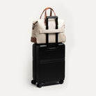 Sac de voyage cabine en toile et cuir, fixé sur trolley pour déplacements professionnels courts.