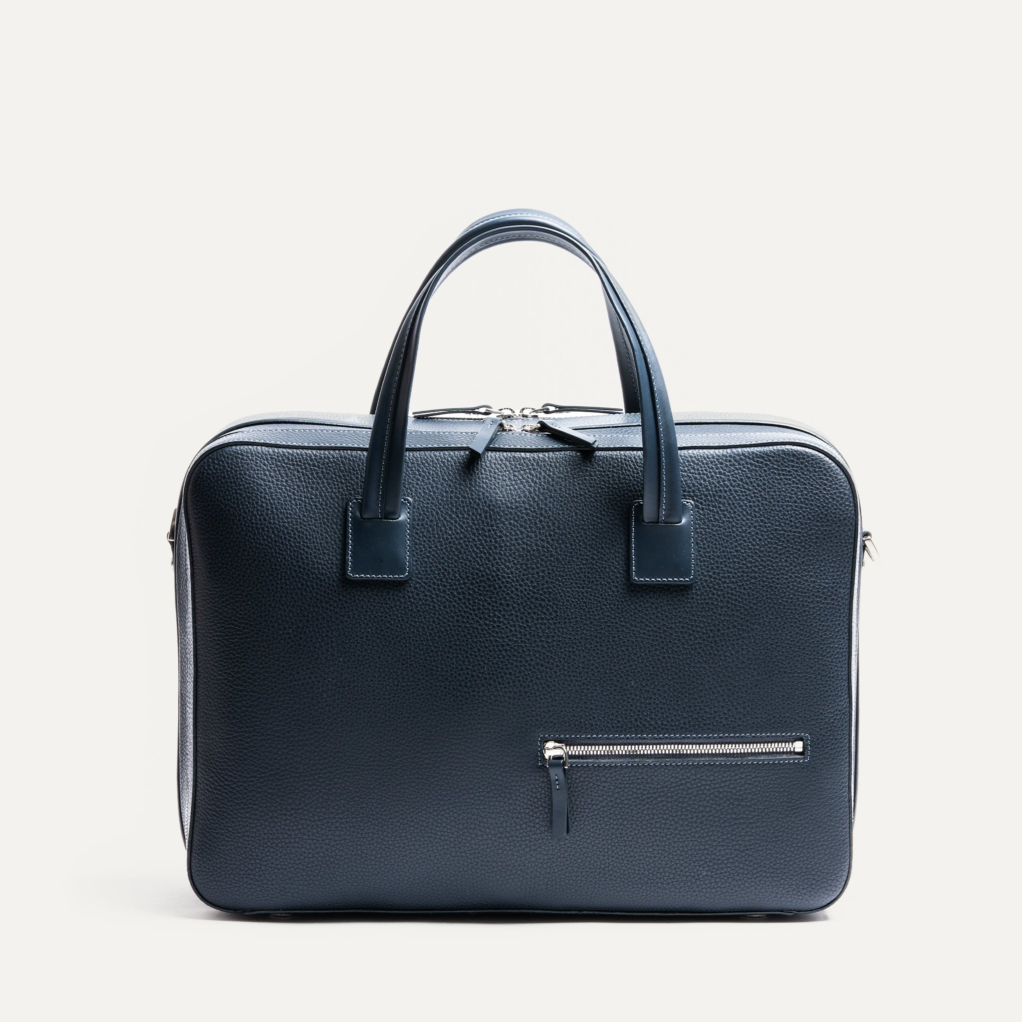 Sac homme travail TILIO II marine est en cuir grainé au tannage semi-végétal, des fermetures éclaires YKK et du cuir pleine fleur lisse au niveau des anses. 