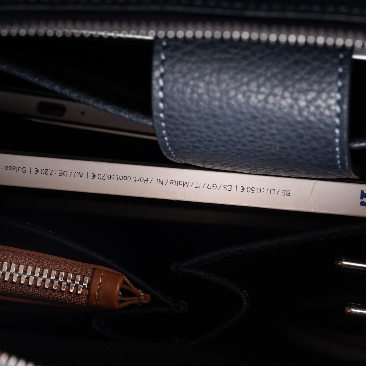 Briefcase en cuir bleu avec finitions premium et compartiments doublés, alliant design et fonctionnalité.