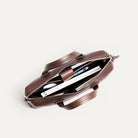 Sac ordinateur en cuir marron avec intérieur compartimenté, conçu pour transporter laptop, documents et accessoires.