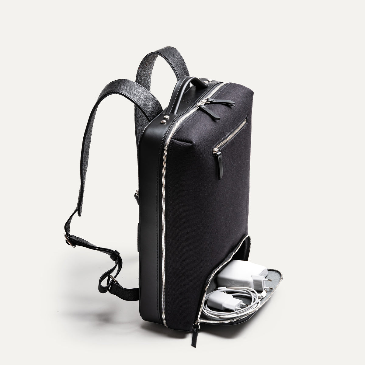 sac à dos tendance homme avec poche basse pour accessoires tech et chargeurs.