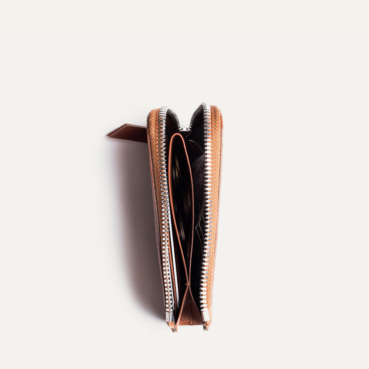 Portefeuille cuir femme ouvert vu de dessus avec un compartiment pièce de monnaie, carte bancaire et billets.